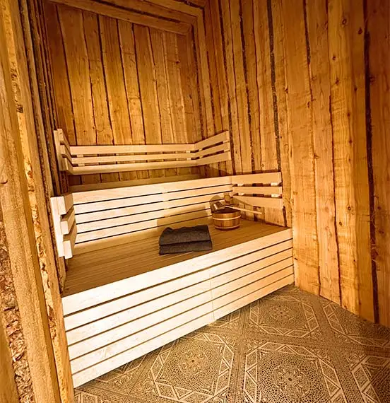 Stammsauna in der Amazon Wellness Suite mit 2 Handtüchern und einem Aufgusskübel mit Löffel
