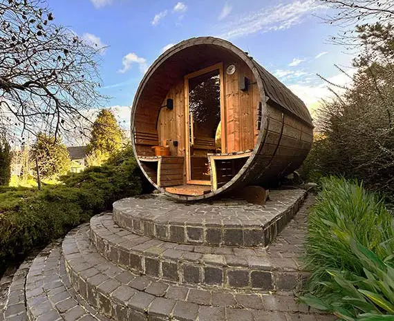 Ton sauna op heuvel in het groen met een stijlvolle ronde trap eronder