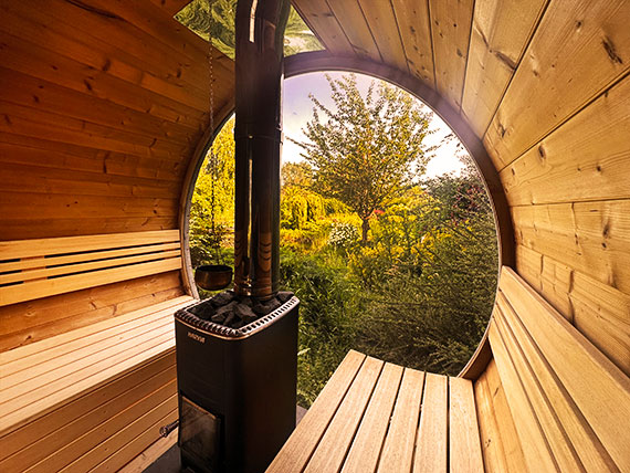 binnenkant ton sauna met uitzicht op de wellness tuin en vijver